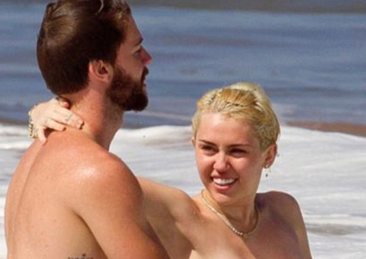 http://www.dailymail.co.uk/tvshowbiz/article-2925741/Miley-Cyrus-goes-topless-frolics-ocean-beau-Patrick-Schwarzenegger.html